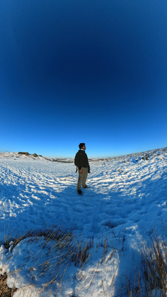 Tapiwa standing in a snow-covered landscape under a clear blue sky